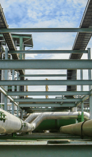 A gray structural steel pipe rack carrying piping on the lower level and cable tray on the upper level.